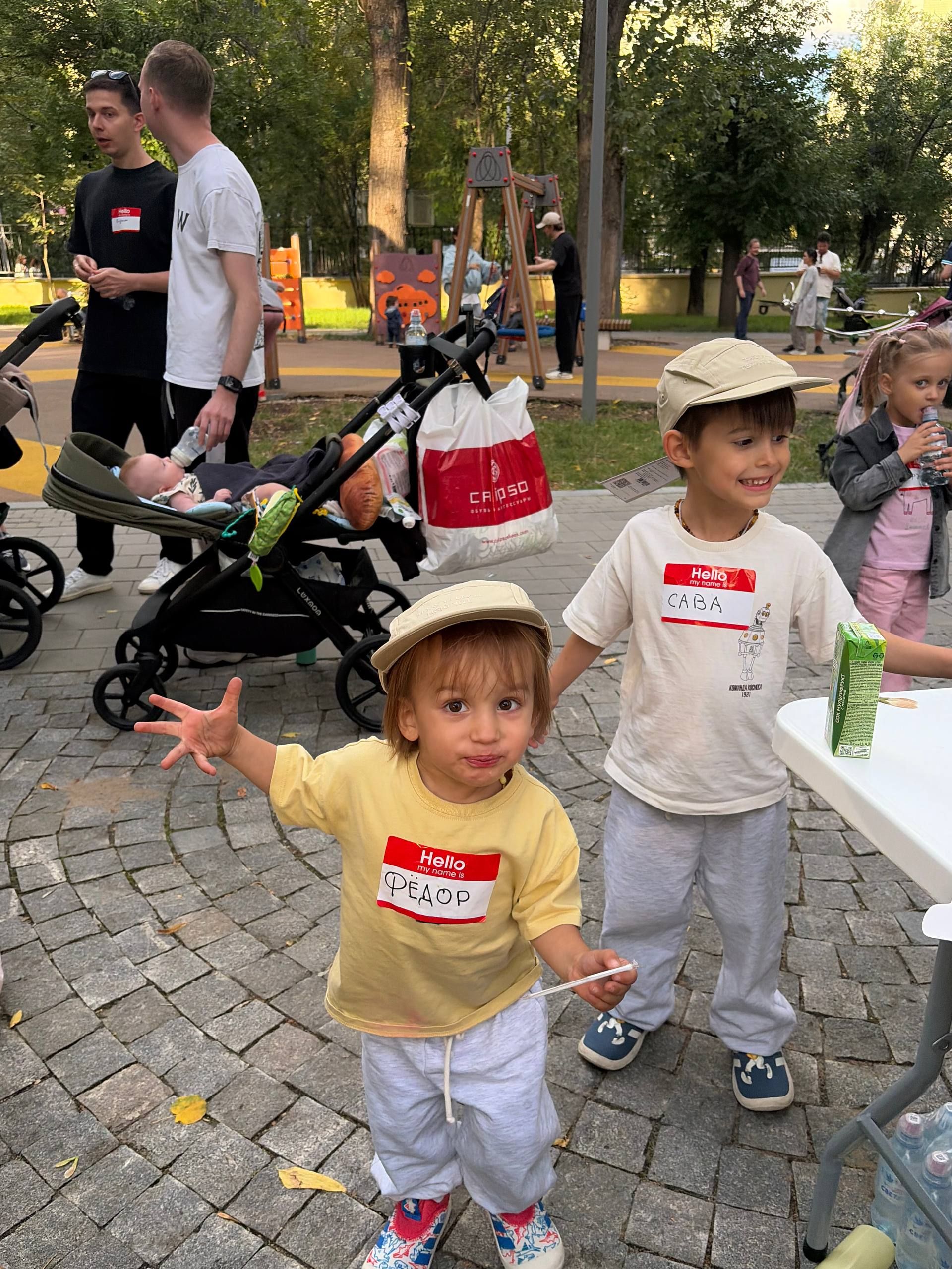 Двое детей в панамах с именными бейджами на встрече