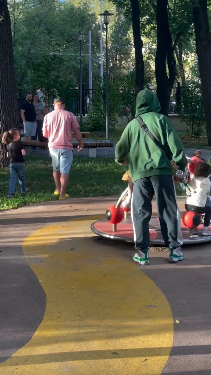Отцы и дети у карусели в саду